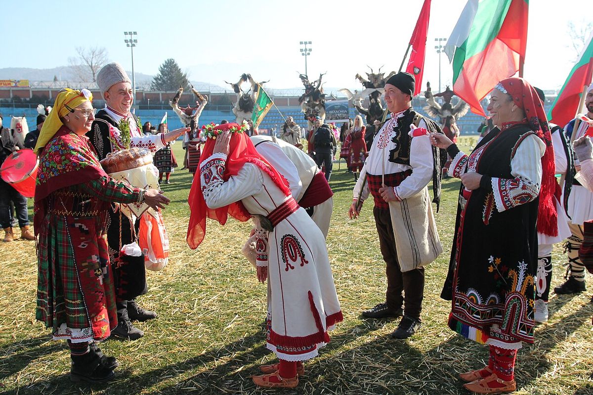 A Bulgarian wedding couple at the ceremony, the bride in white, the groom in a dark suit